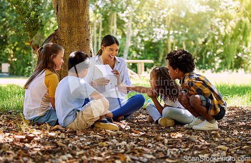 Image of Books, reading or teacher with children in a park storytelling for learning development or growth. Smile, tree or happy educator with stories for education at a kids kindergarten school in nature