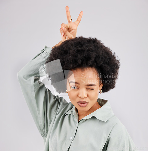 Image of Goofy, happy woman and portrait with a wink, pout and bunny ears hand sign in a studio. Isolated, grey background and peace emoji hands of a female model feeling funny with fun comedy and joke