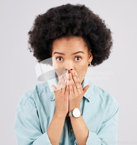 Image of Portrait, hand and mouth with a shocked woman in studio on a gray background feeling surprised by gossip. Face, wow or afro and a young female hearing news with an omg or wtf expression of disbelief