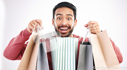 Image of Wow, sale and portrait of man with shopping bag in studio, excited for discount or purchase on white background. Deal, face and indian guy with product from shop, mall or market while posing isolated