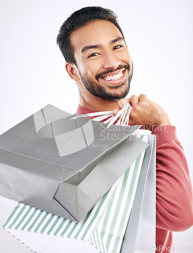 Image of Portrait, retail and Asian man with shopping bags, smile and discount isolated against a white studio background. Face, Japanese male shopper and customer with parcels, package and purchase with joy