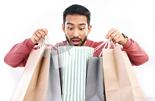 Image of Sale, wow and shocked man with shopping bag in studio, excited for discount or purchase on white background. Deal, omg and indian guy with product from shop, mall or market while posing isolated