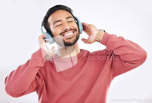 Image of Headphones, moving and man doing a dance in studio to music, playlist or album for entertainment. Happiness, smile and Asian male model dancing to the radio or listening to a song by white background