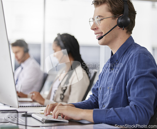 Image of Man, call center and typing on computer, smile in office and working on customer service in workplace. Telemarketing, desktop and happiness of person, male sales agent or consultant consulting online