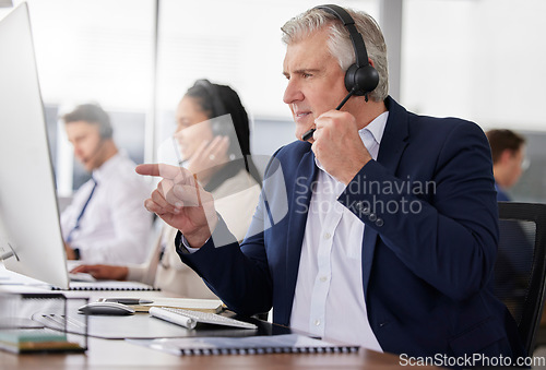 Image of Man, call center and pointing to computer in office while working on customer service in workplace. Telemarketing, focus and mature person, male sales agent or consultant talking or consulting online