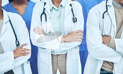 Image of Hands, doctors and group with arms crossed in hospital or clinic for teamwork. Collaboration, nurses or confident medical professionals or people with pride for healthcare, wellness or diversity.