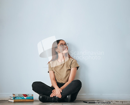 Image of Textbook thinking, student woman and smile by a wall with school notes for learning with happiness. University, college and house with floor sitting of a happy person ready for studying with mockup