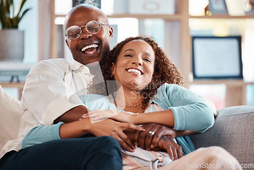 Image of Couple, hug and laughing on sofa portrait in home living room, bonding and having fun. Interracial, love and funny black man and mature woman on couch embrace, relax and enjoying comedy together.