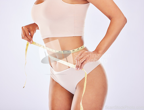 Image of Health, stomach and tape measure woman waist for diet in studio for healthy lifestyle, weight loss or fitness. Female on a white background for wellness and self care motivation or healthcare goals