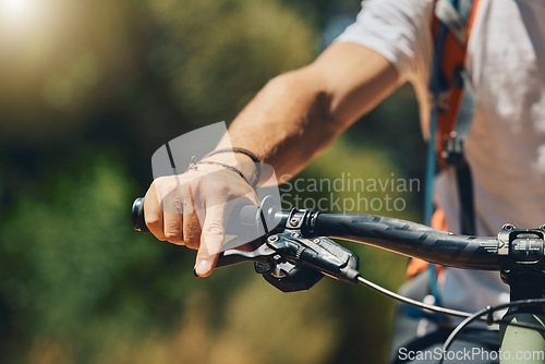 Image of Mountain bike, cyclist hand and brake outdoor in nature in sunshine for safety, extreme sport or lens flare. Man, bicycle and marathon challenge for fast workout, training or exercise for summer race