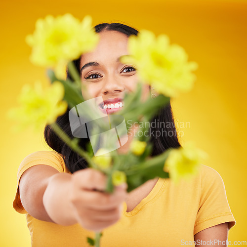 Image of Happy, portrait and woman with flowers as a gift isolated on a yellow background in a studio. Floral, spring and girl giving a bouquet as a present, sharing plants and fresh flower with a smile