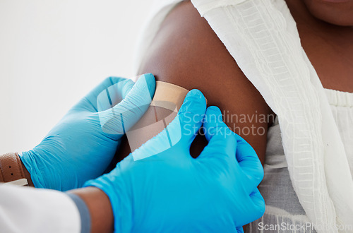 Image of Vaccination, plaster and doctor helping patient with injection or medical vaccine in hospital. Consultation, appointment and hands closeup of healthcare worker putting arm bandage on woman in clinic