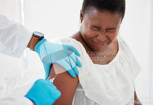 Image of Doctor, black woman and vaccine injection with pain on arm for safety, immunity and prevention. Covid, healthcare and medical professional with vaccination, cure or medicine for sore person in clinic