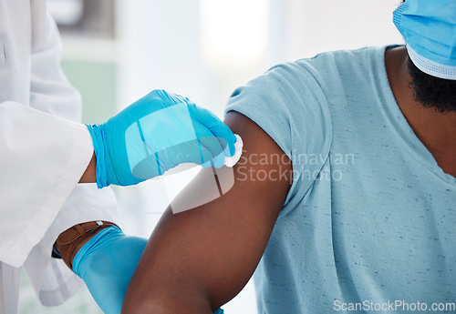 Image of Doctor, hands and cleaning arm before vaccine for health, safety or prevention. Healthcare, covid and medical professional with cotton to disinfect shoulder of black man or patient before vaccination