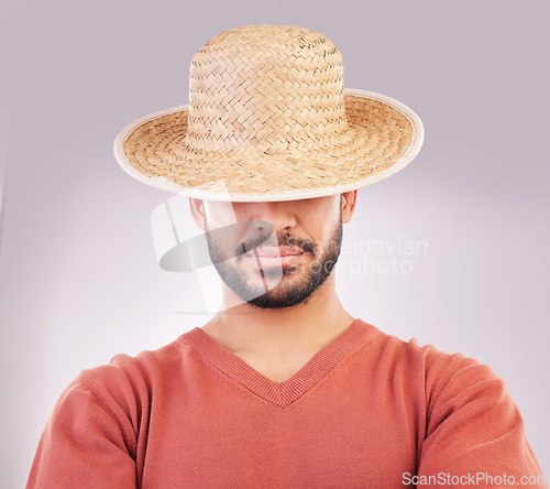 Image of Man, hat and face in fashion style, hidden identity or profile standing isolated against a white studio background. Casual male model posing and wearing straw cap or stylish accessory covering eyes