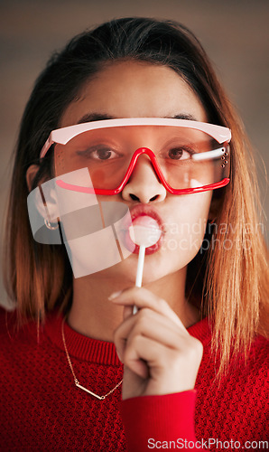 Image of Portrait, fashion and woman with lollipop, glasses and confidence with stylish outfit, edgy and trendy. Face, female and lady with sweets, candy and funky eyewear with cool clothes and creativity