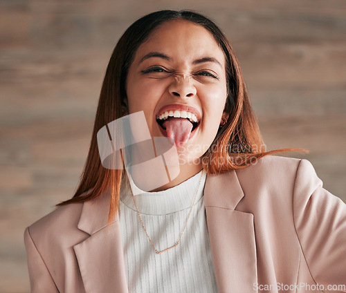 Image of Portrait, tongue and funny face with a woman on a wooden background in studio for comedy, humor or a joke. Comic, crazy and goofy with an attractive young female acting carefree, playful or silly