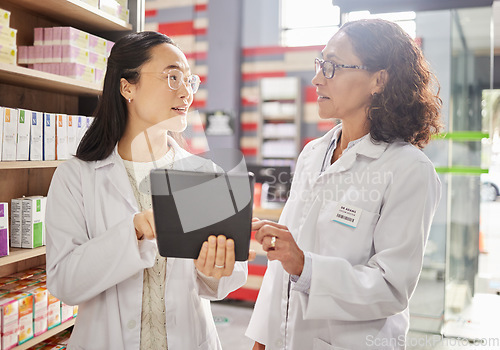 Image of Pharmacy, tablet and stock with women in a dispensary talking about prescription medicine for an online order. Healthcare, technology or diversity with a female pharmacist team working in a drugstore