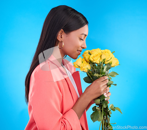 Image of Smell, flowers and bouquet with woman in studio for gift, satisfaction and spring. Relax, happy and floral present with female and roses isolated on blue background for aroma, natural and products