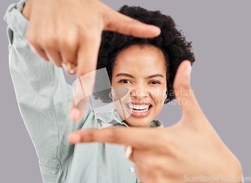 Image of Happy, portrait and woman with hand frame in a studio posing with a positive face expression. Happiness, smile and headshot of an African female model with a finger border isolated by gray background