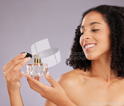 Image of Beauty, self care and woman in a studio with perfume for a fresh scent, bodycare or wellness. Happy, smile and female model with bottle of fragrance for cosmetic health isolated by a gray background.