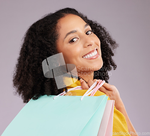 Image of Woman, face and portrait smile with shopping bags for discount, sale or fashion against gray studio background. Happy female shopper smiling and holding gifts or shop accessories posing in happiness