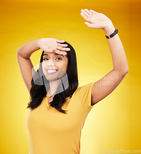 Image of Happy, shy and cover with portrait of woman in studio for excited, surprise and cool. Smile, happiness and creative with female and arm stretching on yellow background for hiding, break and relief