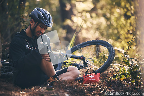 Image of Sports man, injury and first aid outdoor while cycling on mountain bike in nature with leg or knee pain. Athlete person on ground in forest for fitness exercise, training or workout accident or fall