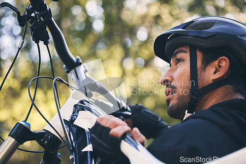 Image of Forest, fitness and cyclist carrying bicycle in nature with helmet, exercise adventure trail and healthy mindset. Cycling, woods and man with mountain bike in trees for workout, motivation or energy.