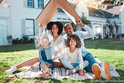 Image of Cardboard roof, portrait and family relax on the lawn of new home, property or real estate, happy and excited. House, gesture and face of kids with parents relax on grass, proud and mortgage success