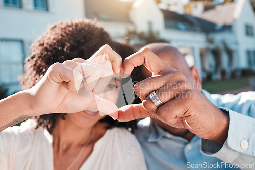 Image of Love, couple and heart hands outside of new house, property or real estate success. Emoji, shape and woman with man in front of dream home in celebration of rental, moving or homeowner milestone