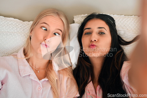 Image of Funny, playful and portrait of women with a selfie for a memory, friendship or comic together. Goofy, silly and friends taking a photo in the bedroom during a sleepover being crazy and joyful