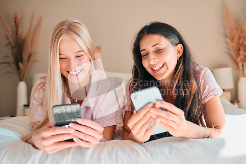 Image of Teen friends, smartphone and girl on bed, relax and smile on face, social media scroll and happiness at home. Technology, young people chat on internet with gen z and phone app with meme online