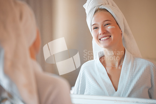 Image of Mirror, skincare and lotion with a woman in a bathroom of the home during her morning beauty routine. Facial, cosmetics and cream with an attractive young female feeling happy while getting ready