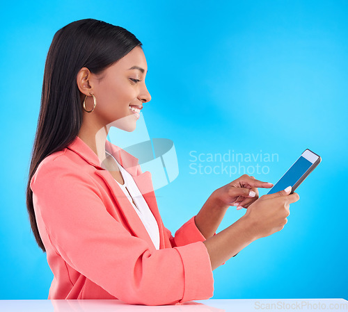 Image of Happy woman, tablet and smile for research, social media or browsing and communication against a blue studio background. Female employee working on touchscreen for business data or search on mockup