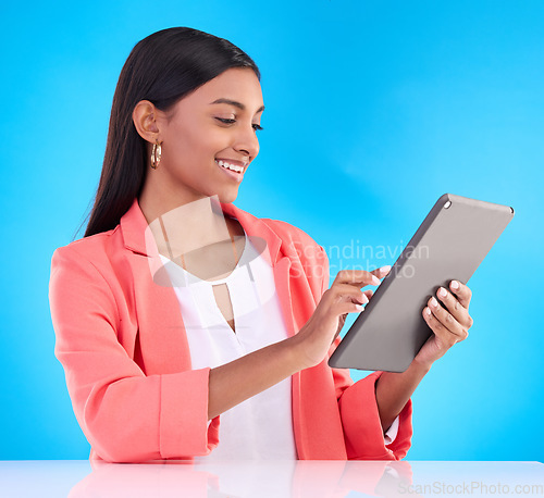 Image of Happy woman, tablet and smile for research, browsing or social media and communication against a blue studio background. Female employee working on touchscreen for business data or search on mockup