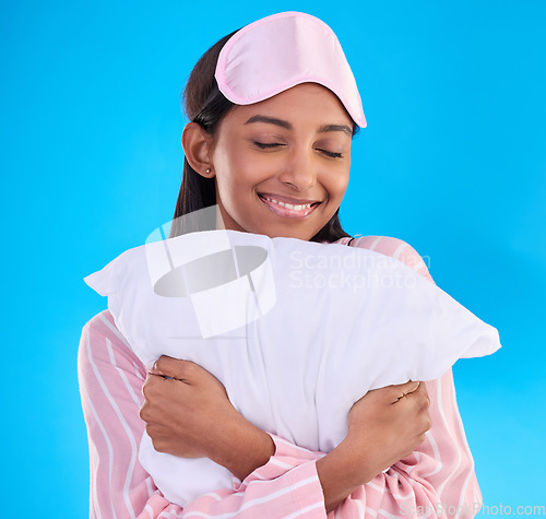 Image of Bedtime, happy and a woman hugging a pillow isolated on a blue background in a studio. Smile, comfy and a girl ready for sleep, nap or slumber in pyjamas for comfort and coziness on a backdrop