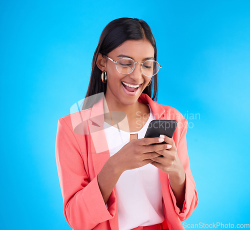 Image of Happy business woman, phone and social media in surprise for deal, discount or online sale against a blue studio background. Excited creative female on smartphone smiling for communication or startup