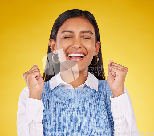 Image of Celebration, winner and fist pump with woman in studio for success, excited and happy cheering. Wow, yes and achievement with female on yellow background for victory, promotion and good news