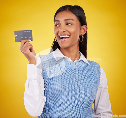 Image of Credit card, excited and Indian woman on yellow background for bank, investment and payment in studio. Banking mockup, finance and happy girl with plastic for budget, commerce and promotion purchase