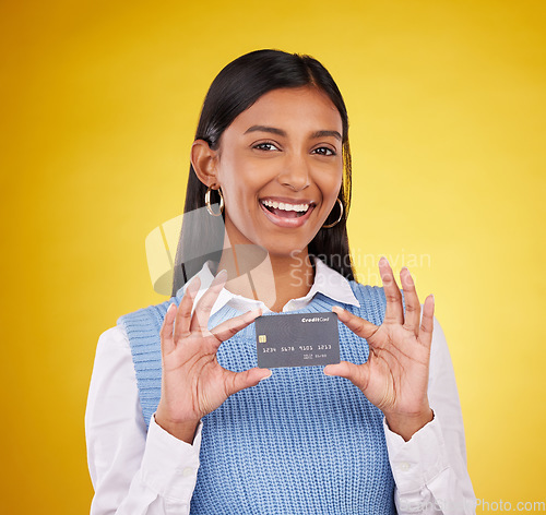 Image of Credit card, smile and portrait of Indian woman on yellow background for bank, investment and payment in studio. Banking mockup, finance and girl with product for budget, commerce and sale purchase