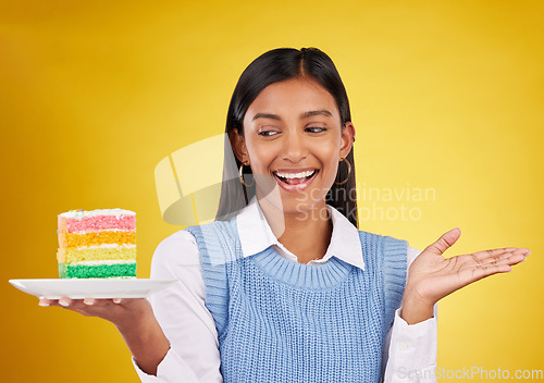 Image of Birthday, smile and woman with cake in studio for happy celebration or party on yellow background. Happiness, excited gen z model with rainbow dessert on plate to celebrate milestone or achievement.