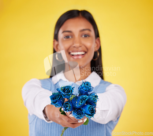 Image of Portrait, love and roses with a woman on a yellow background in studio for valentines day. Face, blue flowers or smile with a happy young female holding a plant for romance or anniversary celebration