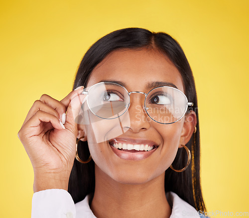 Image of Happy, smile and woman with glasses in a studio for optical health, wellness and awareness. Happiness, optometry and Indian female model with spectacles for eye care isolated by a yellow background.