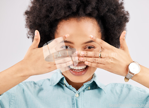 Image of Portrait, hiding face woman and smile in a studio with a person feeling playful or joking for comedy. Eyes, smile and hand gesture with a funny young female looking happy with a positive attitude