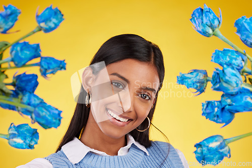 Image of Portrait, love and blue roses with a woman on a yellow background in studio for valentines day. Face, flowers or smile and a happy female posing with plants for anniversary, romance or celebration