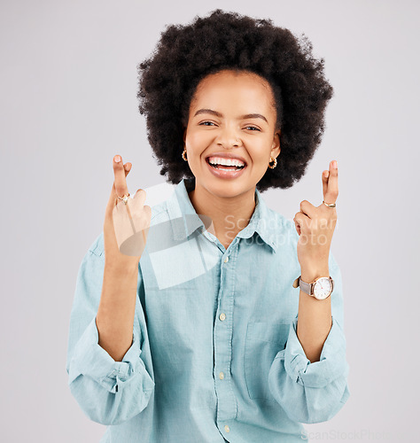 Image of Luck, woman portrait and fingers crossed with hope and smile in a studio with happiness. Isolated, gray background and young female model with hopeful and emoji hand sign laughing and waiting for win