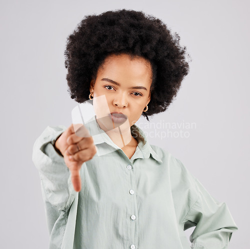 Image of Portrait, thumbs down and black woman serious in studio isolated on a white background. Hand gesture, person or female with dislike emoji, negative opinion or no, rejection or failure, vote or wrong.