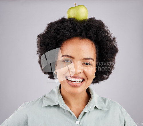 Image of Apple on head, balance and portrait of black woman in studio for nutrition, wellness and healthy snack. Food, diet and girl smile with fruit for detox, vitamins and weight loss on white background