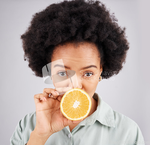 Image of Portrait, orange and black woman fruit in studio isolated on a white background. Food face, nutritionist and serious person or female with vitamin c, nutrition or healthy diet, citrus or vegan detox.